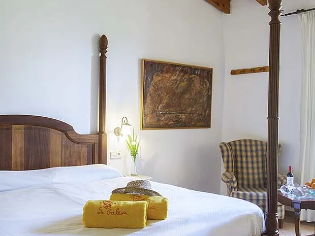Deluxe-Doppelzimmer mit Himmelbett unter Holzbalken