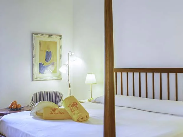 Doppelzimmer mit Holzbett und Fenster ins Grüne