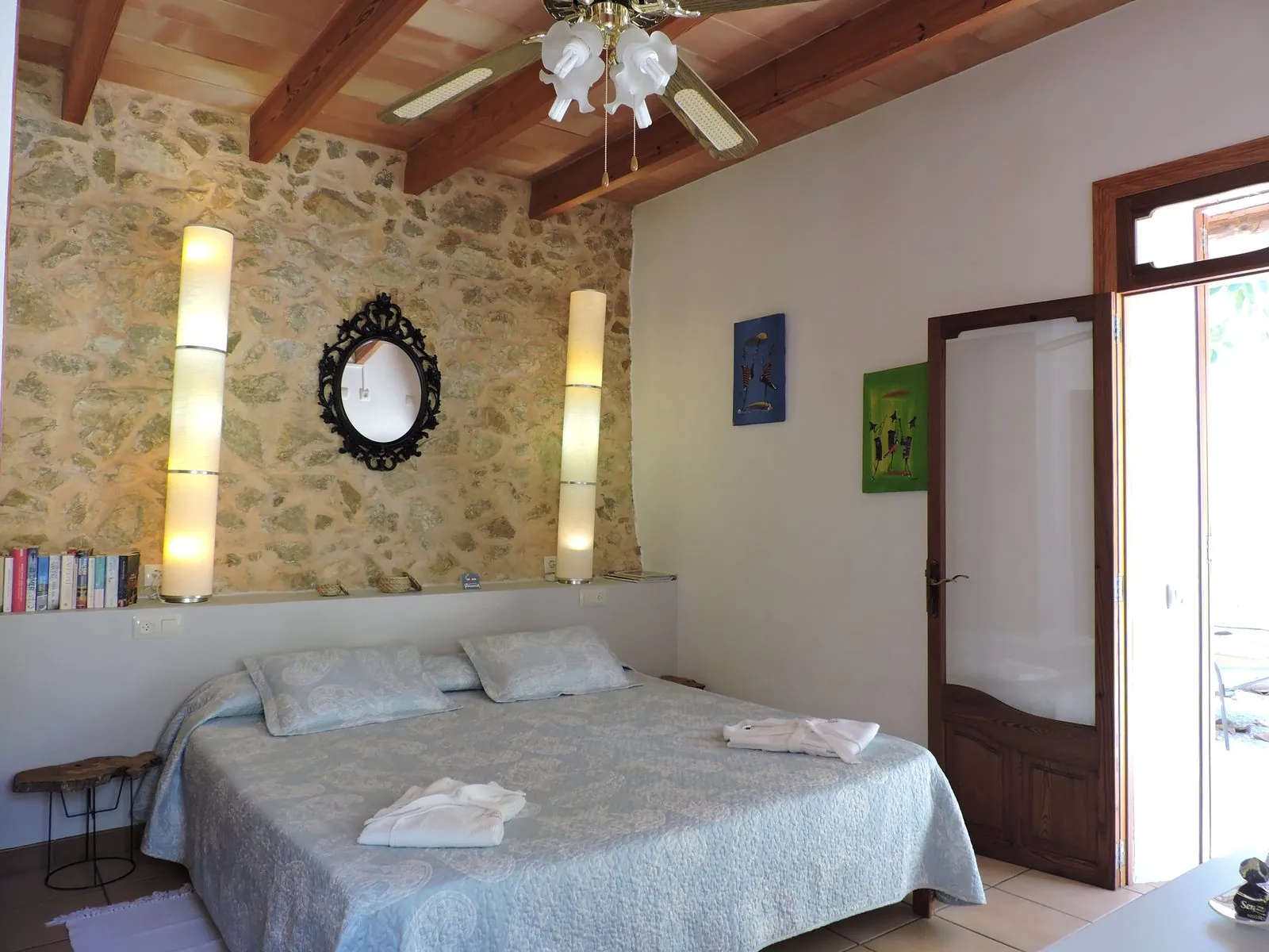 Doppelzimmer mit Natursteinwand und Deckenventilator